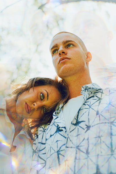 A man in a white shirt and blue button next to the woman in a white shirt
